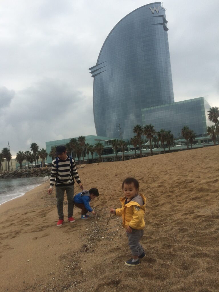 wバルセロナ前のビーチで遊ぶ家族